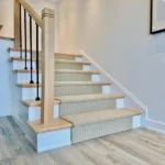 Beige patterned carpet runner on modern wood stairs.
