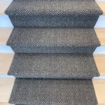 Close-up of geometric grey carpet on stair treads
