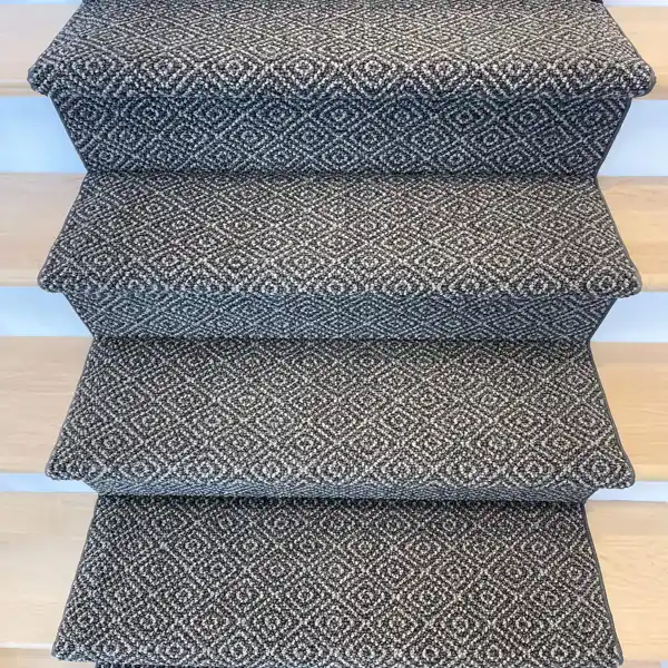 Close-up of geometric grey carpet on stair treads