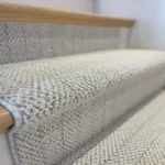 Close-up of gray patterned carpet on a stair nose