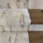 Close-up of white and grey carpet texture on a stair