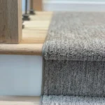 Detail of carpet runner edge against white riser