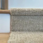 Detail of carpet runner edge on a wooden stair