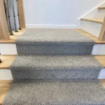 Front view of grey carpet runner on three wood steps