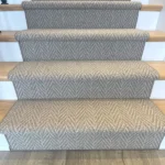 Front view of patterned carpet runner on wood stairs