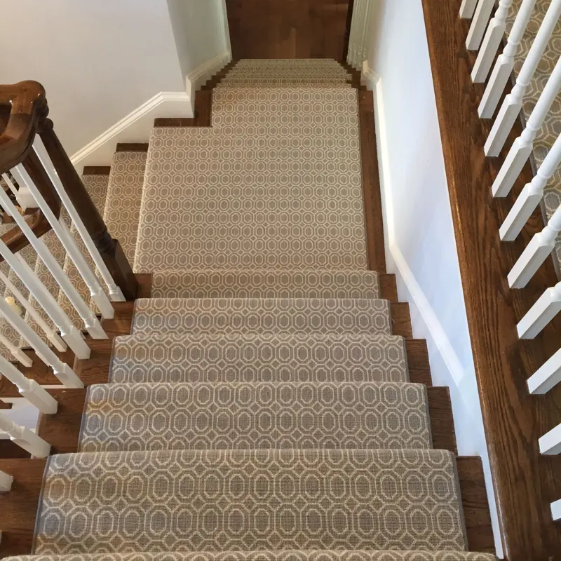 Geometric patterned tan runner on wood stairs