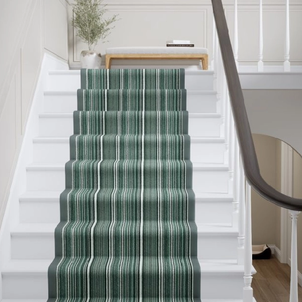 Green and white striped Wool Biscayne stair runner on white stairs.