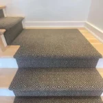 Grey diamond-pattern stair runner with landing.