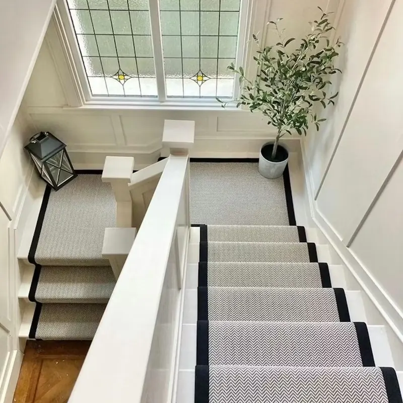 Herringbone runner with black border on white stairs