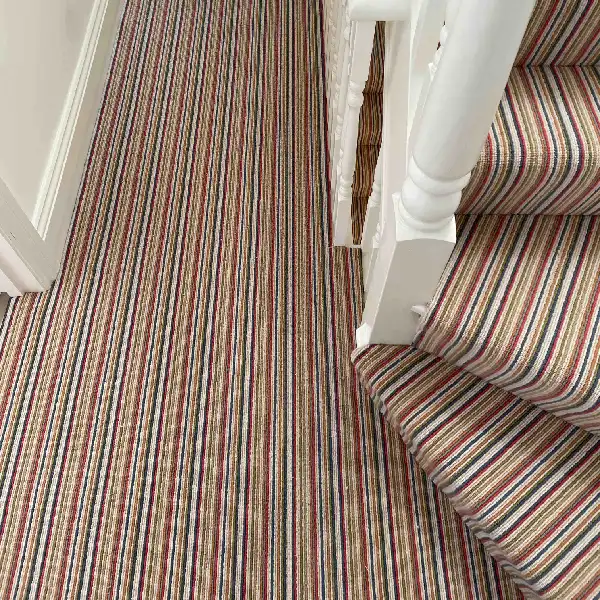 Multi-colored Wool Mississippi striped carpet on a landing and stairs.
