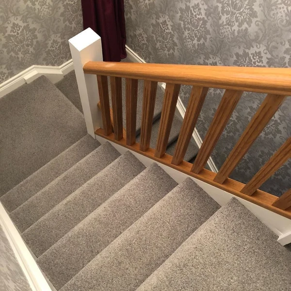 Neutral cut and loop pile carpet on wooden stairs