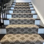 Patterned carpet runner on dark wood stairs.