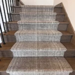 Plaid carpet runner on dark wood stairs