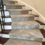 Rich brown wood stairs with a neutral carpet runner.