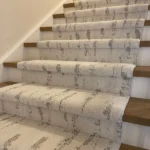 Side perspective of carpet runner on wooden staircase